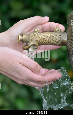 Hand pressing button on a bubbly water fountain Stock Photo