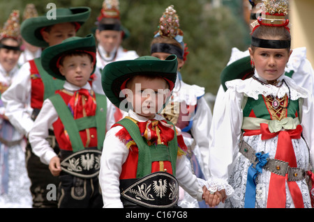 Children wearing traditional costumes of the Val Gardena Valley during a traditional procession in the village of Santa Cristina Stock Photo