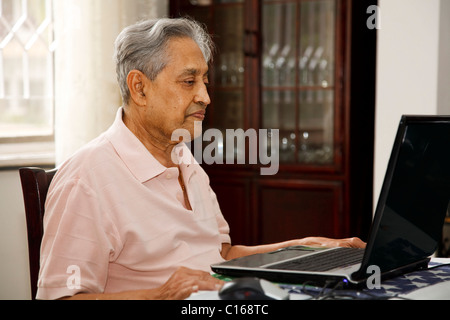 Elderly Indian man using a laptop computer at home Stock Photo
