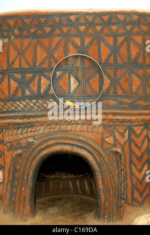 Low entrance and a ring as talisman surrounded by abstract fresco murals painted by Gurunsi women on the walls of the fortified Stock Photo