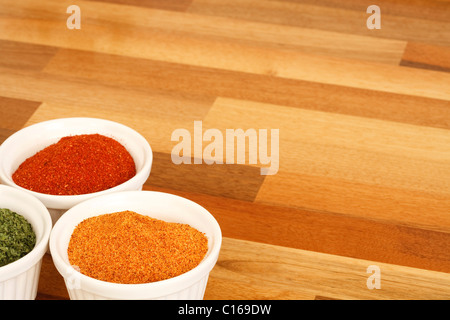 Bowls of spice on a wooden kitchen worktop Stock Photo