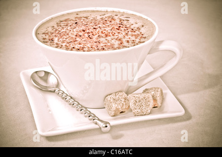 Cappuccino in white cup and with cubes of brown sugar Stock Photo