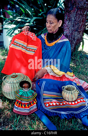 An elderly Miccosukee Indian woman displays traditional clothing and handicrafts at her Seminole tribal village in The Everglades in Florida, USA. Stock Photo