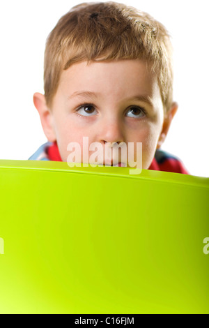Boy looking over the back of a chair Stock Photo