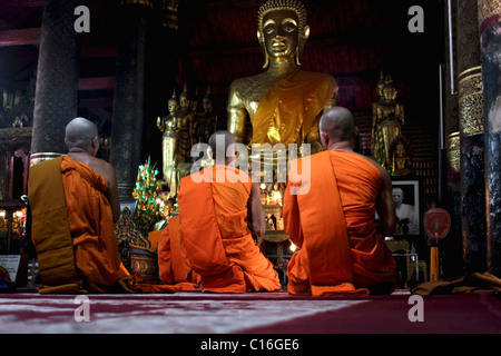 A group of monks are paying homage to Buddhist teachings before the Pi Mai celebration at Wat Mahathat in Luang Prabang, Laos. Stock Photo