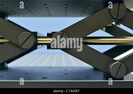 fragment of lab jack mechanism on the steel table; used in opto-mechanics and research; selective focus on front screws and axis Stock Photo