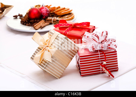 Christmas presents next to a plate with Christmas decorations Stock Photo