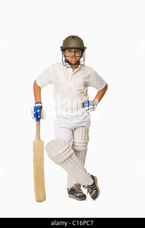 Boy in cricket uniform holding a cricket bat Stock Photo