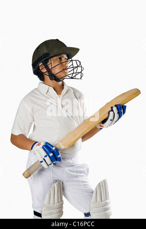 Boy in cricket uniform holding a cricket bat Stock Photo