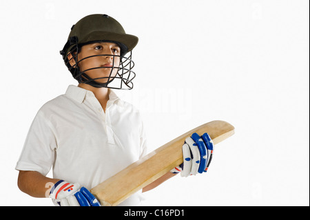 Boy in cricket uniform holding a cricket bat Stock Photo