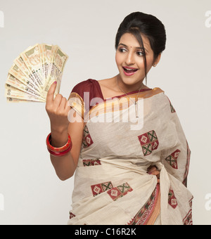 Woman holding Indian five hundred rupee notes and smiling Stock Photo