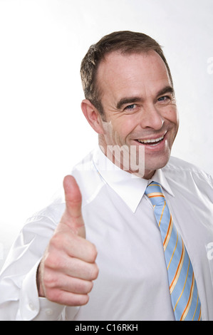 Laughing businessman indicating thumb up Stock Photo