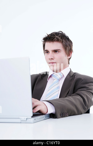Young businessman sitting in front of laptop Stock Photo