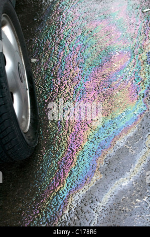 Petrol leaking from car in supermarket car park causing pollution Stock