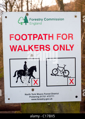 Forestry Commission England sign notice Footpath for walkers only with images showing no horses or bicycles