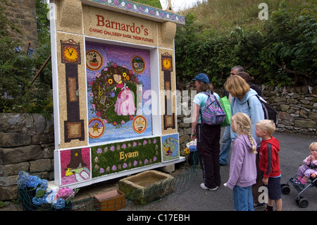 Looking at well dressing in Eyam, Derbyshire, UK Stock Photo