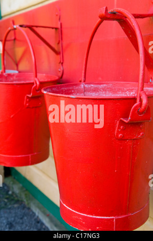 Two Red Painted Water Buckets Hanging Up Stock Photo