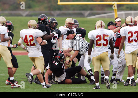 Referees try to break up an altercation between Catholic University and Bridgewater College players during a football game. Stock Photo