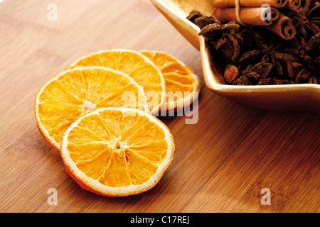 Dried orange slices on a wooden board with star anise and cinnammon sticks Stock Photo