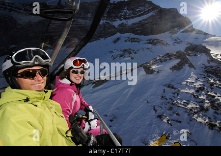 Skiers in ski lift to Scex Rouge, Col du Pillon, skiing region Glacier 3000, Gstaad, Western Alps, Bernese Oberland, Switzerland Stock Photo