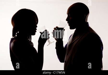 Silhouette of a man and a woman drinking wine. Stock Photo