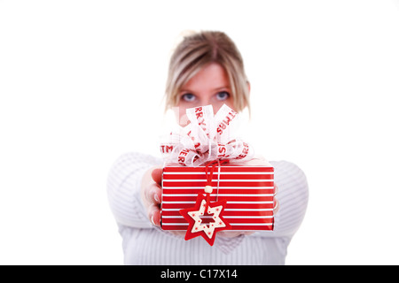 Woman holding a christmas present, symbolic picture for giving presents Stock Photo