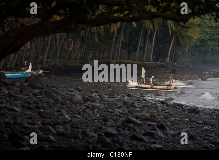 Balinese fishermen pull up on the beach in Tembok, Bali, after a night of fishing for mackerel in a traditional outrigger. Stock Photo