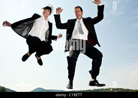 Businesswoman and businessman jumping Stock Photo