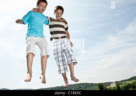 Two boys jumping on trampoline Stock Photo