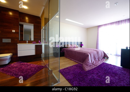 Bedroom with bathroom separated by glass Stock Photo
