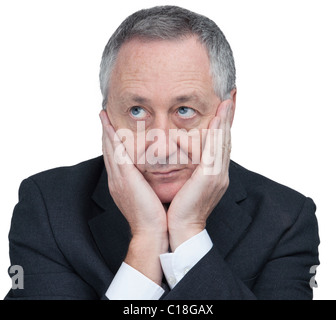 business man holding head in hands looking up and sideways against a white background. Confused man. Stock Photo