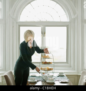 Woman setting up table Stock Photo