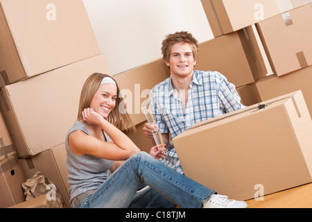 Moving house: Happy couple celebrating with glass of champagne new home Stock Photo