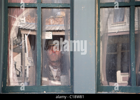 Cowboy seen behind windows on the set at Eaves Movie Ranch, Santa Fe, New Mexico Stock Photo