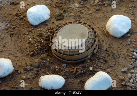 A land mine is a target (person or vehicle) triggered explosive weapon mine are marked with white stone during clearing Stock Photo