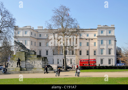 Exterior Neoclassical  Lanesborough Hotel 5 stars expensive luxury hotel with red London bus on blue sky day winter trees Hyde Park Corner London UK Stock Photo