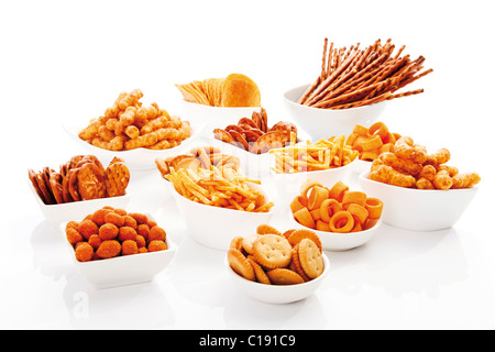 Various spiced snacks in bowls, crisps, peanut flips, pretzel sticks, potato sticks and salted cookies Stock Photo