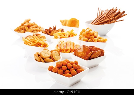 Various spiced snacks in bowls, crisps, peanut flips, pretzel sticks, potato sticks and salted cookies Stock Photo