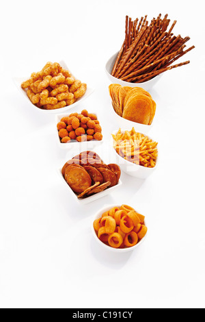 Various spiced snacks in bowls, crisps, peanut flips, pretzel sticks, potato sticks and salted cookies Stock Photo