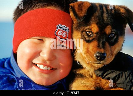 Inuit boy with dog from Nuiqsut, on the coast of the Arctic Ocean in the far north of Alaska Stock Photo