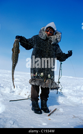 Inuit woman with a caught migratory Artic Char, Nuiqsut, on the coast of the Arctic Ocean in the far north of Alaska Stock Photo