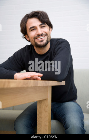 Man sitting at a wooden table Stock Photo