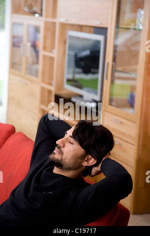 Man sitting on a sofa, relaxing Stock Photo