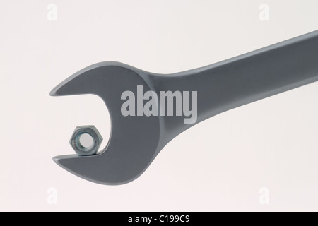 A too big chrome wrench for nut symbolizing failure, problems, challenge or success. Isolated on white background Stock Photo