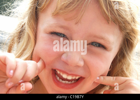 Cute girl making a funny smiling face for the camera. Stock Photo