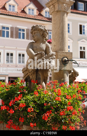 Town fountain on Marienplatz square in Weilheim, Putto figure sculpted by Roman Anton Boos, Pfaffenwinkel, Upper Bavaria Stock Photo