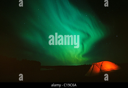 Aurora Borealis over illuminated tent, Alaska, USA Stock Photo