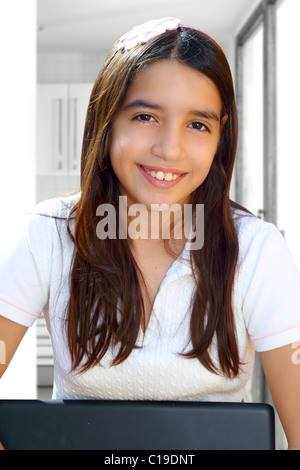 Latin teenager student smiling holding laptop indoor white house Stock Photo