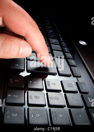 Human finger is pressing ENTER button on computer keyboard... Stock Photo
