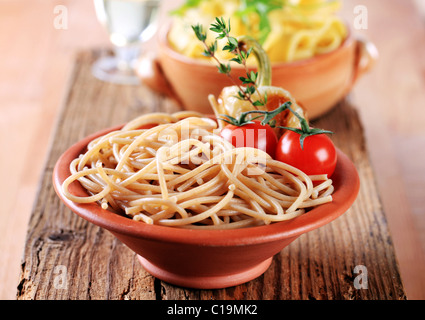 Cooked whole wheat spaghetti in a terracotta bowl Stock Photo